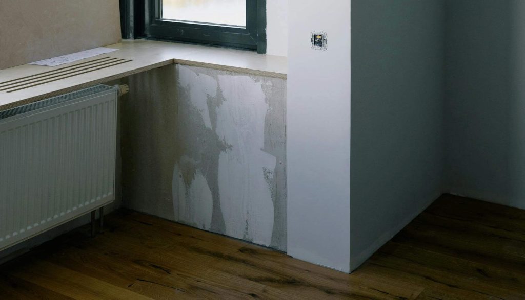 Water-damaged wall being repaired